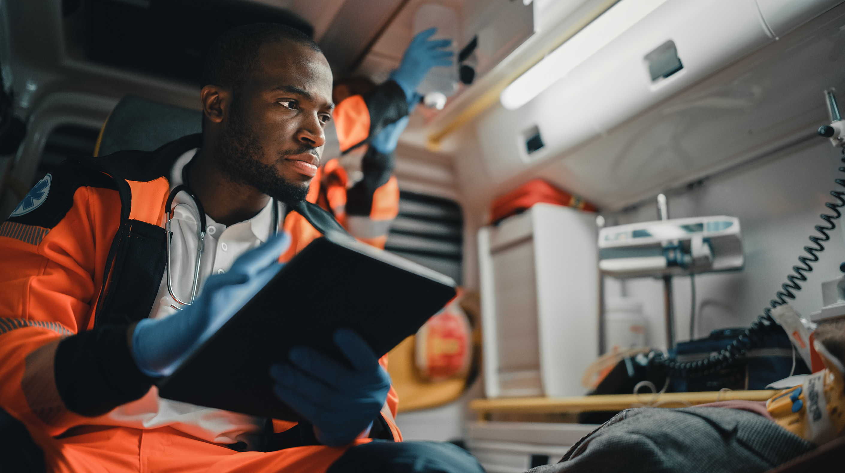 Public safety worker taking notes on a clipboard while aboard an ambulance.
